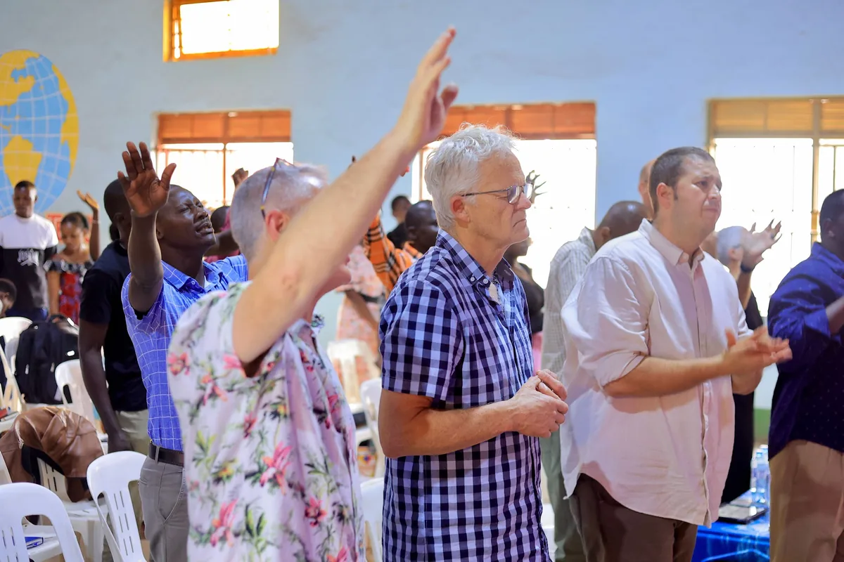 A man standing with his arms lifted in worship