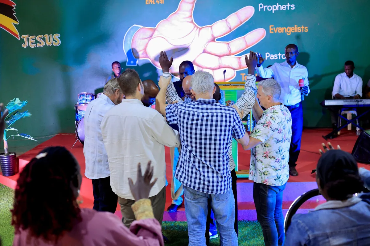 Visiting partners praying with members of the ministry