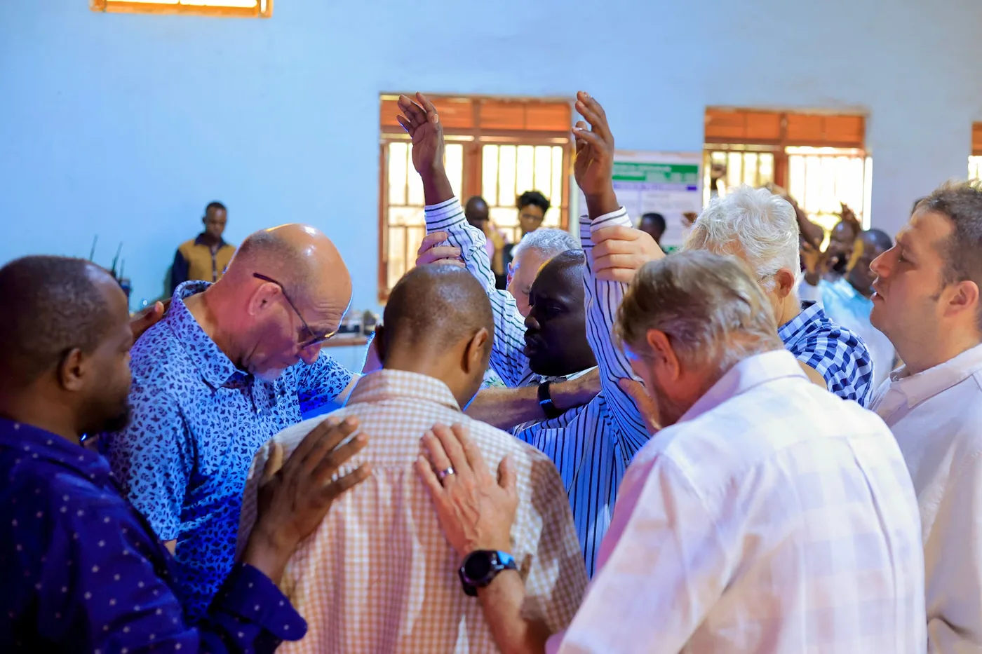 Members laying hands on one another in prayer